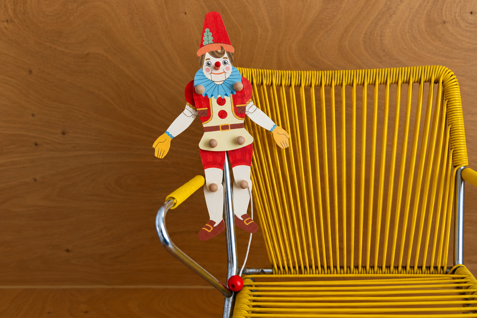 Pinocchio_en_bois_sur_fauteuil_jaune.png